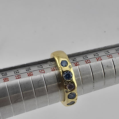 Gold PLATED ring with blue stones on a metal rod with measurement scale