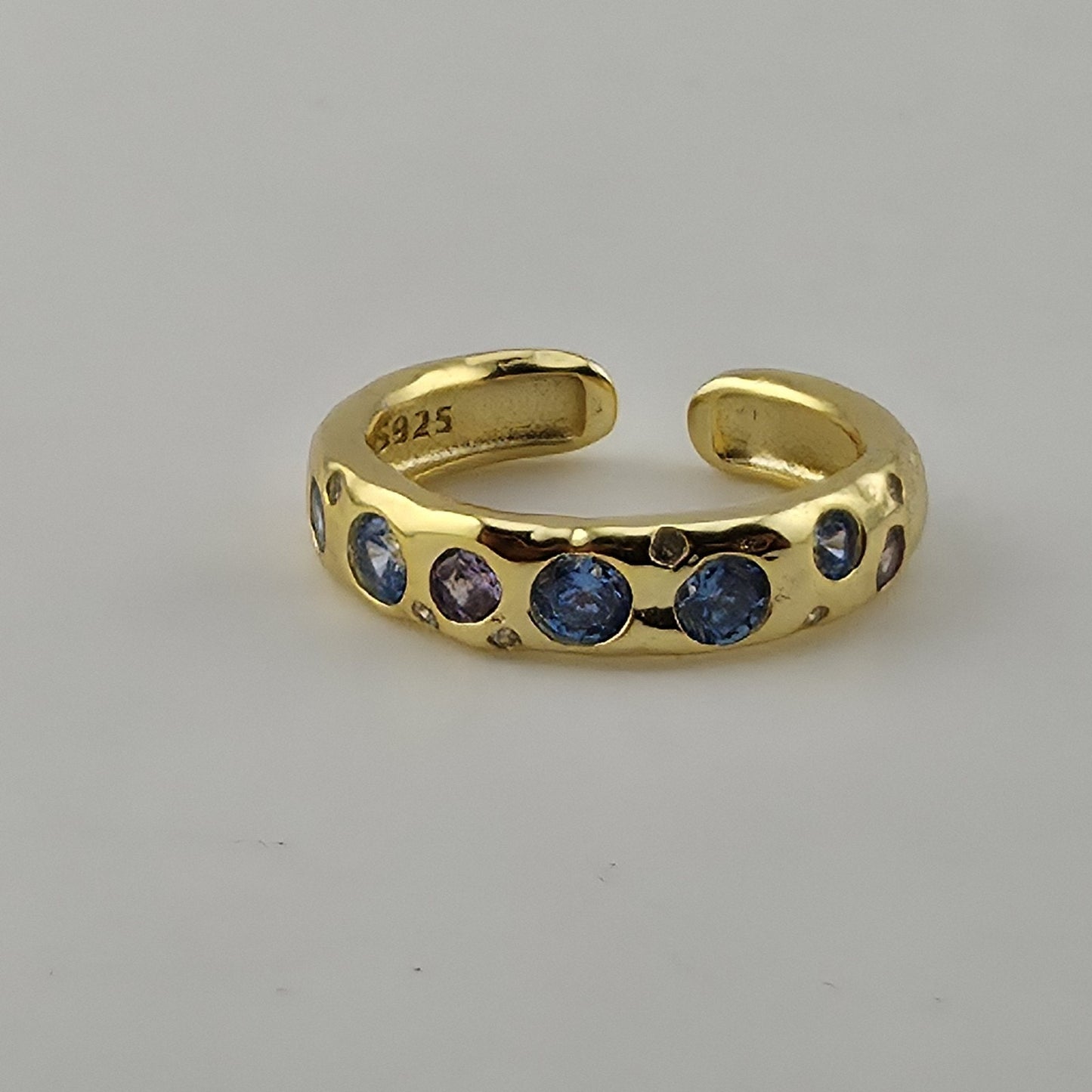 Adjustable open band zircon ring shown on ring mandrel