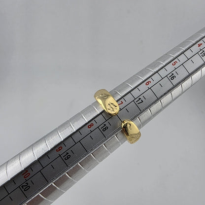  gold PLATED 18K on a ruler for size reference against a gray background
