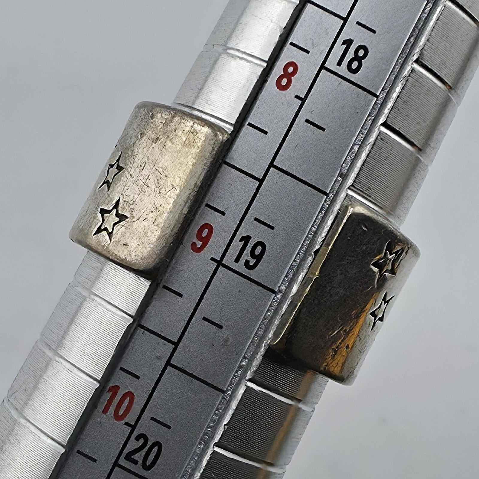 Metallic ruler with star designs on a gray background